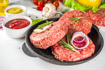 Cooking burger background. Set various cheeseburger  and beefburger ingredients - bun, tomatoes, onion, lettuce, sauces, cheese and raw burger cutlets, ready for barbecue grill. Burger bbq party fest 