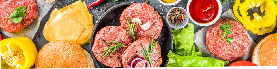 Cooking burger background. Set various cheeseburger  and beefburger ingredients - bun, tomatoes, onion, lettuce, sauces, cheese and raw burger cutlets, ready for barbecue grill. Burger bbq party fest 