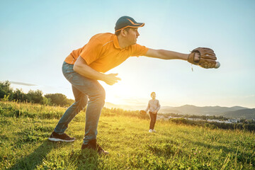Father and son playing in baseball. Playful Man teaching Boy baseballs exercise outdoors in sunny day at public park. Family sports weekend. Father's day.