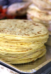 Silver tray with a stack of khachapuri national dish cooked in nature on a barbecue grill. Bread, cheese, eggs baking, the concept of delicious national home-made food with cheese and egg