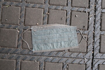 Thrown away face mask on the floor at a bus stop in munich