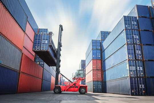 Container Ship Loading Of Import/Export Freight Transportation Industry, Transport Crane Forklift Is Lifting Box Containers At Port Cargo Shipping Dock Yard. Logistic Freighting Ship Service