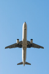 Airplane from below in a blue sky