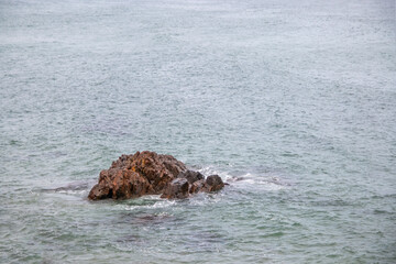 Obraz premium Rock standing in the middle of the ocean