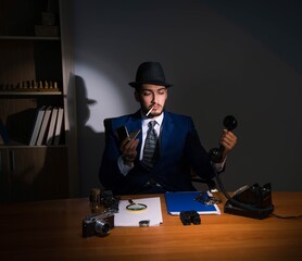 Detective sitting in dark room in vintage concept