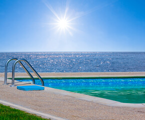 Obraz na płótnie Canvas swimming pool near a sea coast under a sparkle sun