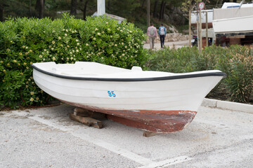 Boat in pavement ground parking by the shore