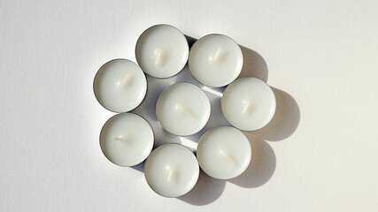      circle of round white candles on a white background                                  