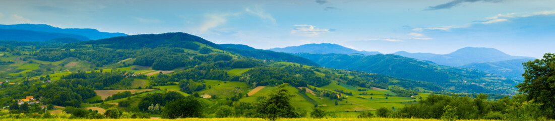 Panorama of Serbia landscape. Mountain village in summer. Blue sky and green valleys.