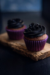 Dos cupcakes de chocolate en una tabla de madera vieja