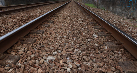 Railway close up. Rails. Perspective.
The rails go into the distance and are connected at one point.