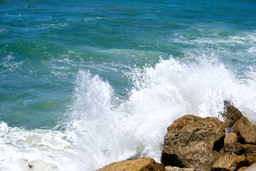 Fototapeta premium Sea wave crashing into a rock and makes the water splash and white air foam bubble, rocky beach in Tel-Aviv Israel