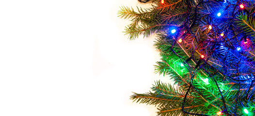 Christmas white background with spruce branches and colorful garlands. Fir branches are located on the side of the frame. Design template for Happy New Year and Marry Christmas.