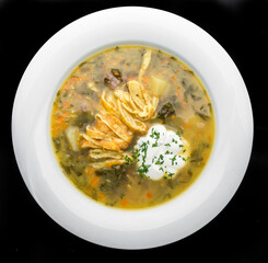 Vegetable soup with omelette rolls in a bowl on rustic wooden table. Diet soup with omelette, carrot, peas, leek, cauliflower and potatoes. Closeup. Top view