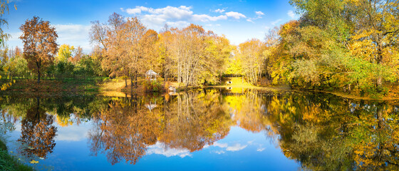 Sunny autumn landscape with blue sky over lake