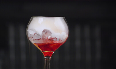 Glass of red cocktail with dry ice
