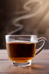 Close up hot tea cup on wood table . hot tea in handle glass with copy space for text or design.