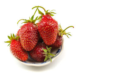 ripe strawberries in a plate on a white isolated background close-up