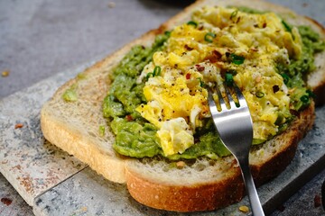 Avocado scrambled egg toast on sourdough bread, selective focus