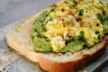 Avocado scrambled egg toast on sourdough bread, selective focus