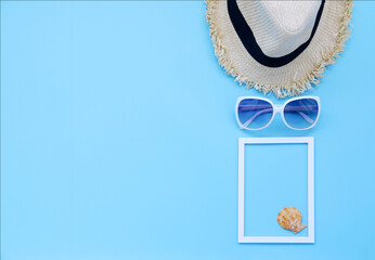 Beach hat,glasses,Picture frame and shellson Blue background In the summer Asia,copy space,Top view,minimal style