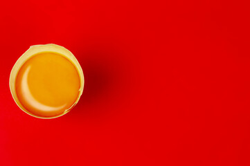 Obraz na płótnie Canvas Raw egg yolk on red background with copy space. B