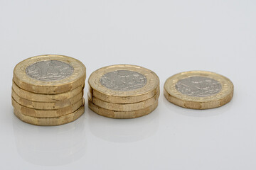 Stacks of UK Sterling pound coins on a white background