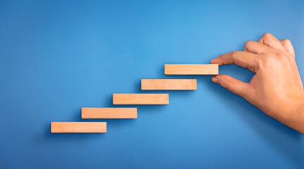 Business person arranging the wooden block steps. Concept of business growth and success. Success...