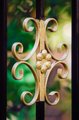 Fragment of a forged lattice, a beautiful pattern on an iron forged fence. Close-up.