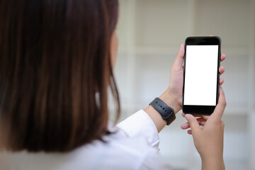 Cropped shot view of woman hands holding smart phone with blank copy space screen for your text message or information content, female reading text message on cell telephone during in urban setting.