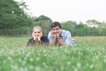 Happy couple laying down on the grass in the park