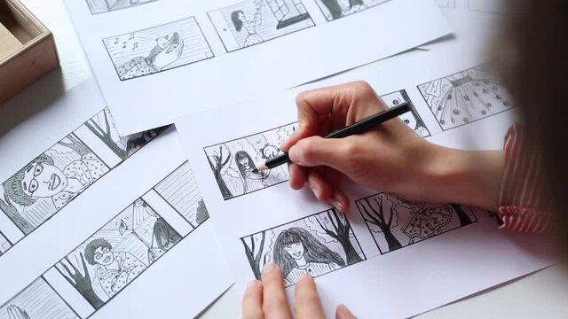 Hands of the artist designer draw a storyboard on paper. Storytelling. Story frames with heroes.