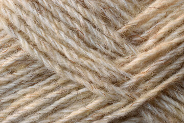 Natural sheep coarse wool yarn texture. Undyed light brown yarn background. Closeup