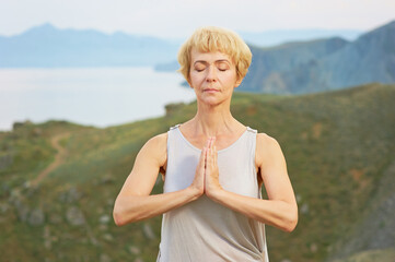 Fototapeta na wymiar Senior woman doing yoga exercises