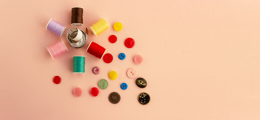 Accessories for needlework on a plain background. Spools of thread, buttons, tape measure, sewing accessories. Set for needlework top view. Place for text.