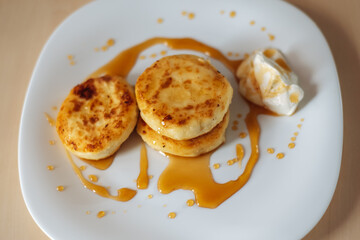 cottage cheese pancakes with honey and sour cream, delicious and healthy Breakfast, beautiful early Sunny morning, healthy food concept