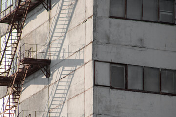 Fototapeta premium Large windows of the building with a ladder for workers on the side