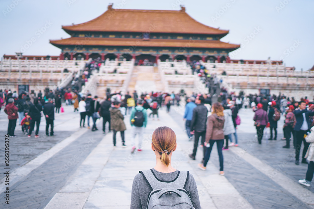 Wall mural Enjoying vacation in China. Traveling young woman with rucksack in Forbidden City, Beijing.