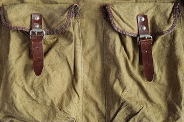 Pockets of a old crumpled vintage army military backpack, made of khaki color camouflage tarpaulin...