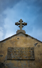 Old cross on ancient church roof with sky england