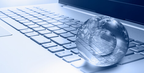 Glass globe on laptop keyboard "Elements of this image furnished by NASA "