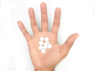 Fototapeta na wymiar White pills on hand on white background with clipping path included.