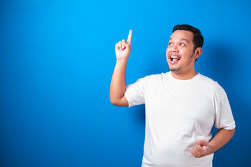 Photo image of Fat Asian man in white t-shirt looked happy thinking and looking up, having good...