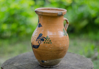 Old clay jug. The girl holds a jug in her hands.