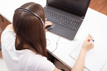 Webinar. Girl in headphones with a microphone in front of a laptop