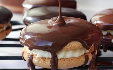 Dripping chocolate ganache over sandwich cookies on wire rack © whiteaster