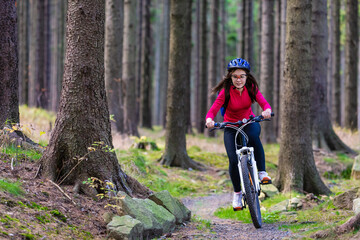Naklejka premium Healthy lifestyle - teenage girl biking in forest 