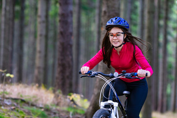 Fototapeta na wymiar Healthy lifestyle - teenage girl biking in forest 
