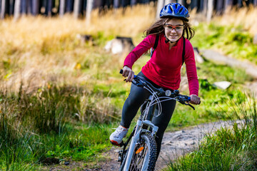 Healthy lifestyle - teenage girl biking in forest
