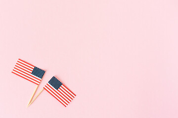 Two american flag on pink background, flat lay. 4th of july, usa independence day. Celebration in America. Copy space for text.